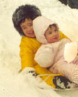 Anton and Erica on a sled on the deck of the house, 1974